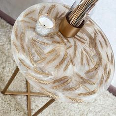 a table with a candle and some straws in it on top of a rug