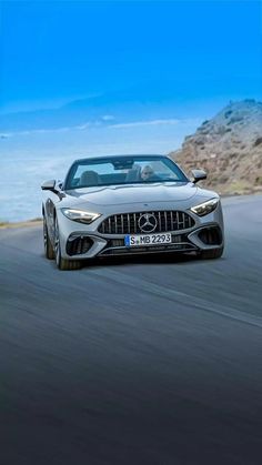 the mercedes amg gt roadster is driving on a road