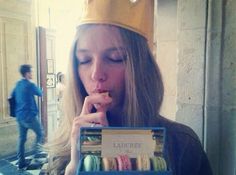 a woman wearing a crown is eating donuts