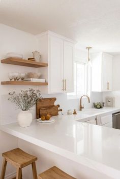 a kitchen with white counter tops and wooden stools