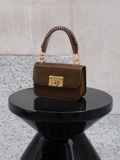 This product is made with at least 20% sustainable materials by weight. CHARLES & KEITH uses recycled, degradable, organic, and water-based materials in our eco-conscious collection. This timeless dark brown version of our metallic turn-lock bag is an investment piece that you can carry for all occasions. Featuring gold-toned hardware and a metallic turn-lock closure that opens up into a surprisingly spacious interior, this classy and compact piece can hold all your must-have items with ease. Carry yours by the top handle, or simply clip on the adjustable strap to turn it into a crossbody bag so you can go hands-free. Minimalist Bags, Charles And Keith, Minimalist Bag, Size Chart For Kids, Classic Bags, Charles Keith, Must Have Items, Neutral Tones, Handle Bag