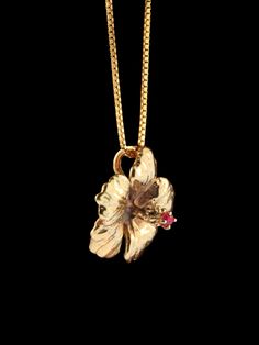 "This Hibiscus Flower will always be in style and in bloom. True to life, the stamen extends from the heart of the flower and is set with a brilliant ruby. The detailed charm is cast in solid 14k gold and is 3/4\" across. The Hibiscus is the national flower for Okinawa, Japan. This item usually ships the same or next business day. All Marty Magic Jewelry is packaged in a beautiful box, embossed with the gold foil Marty Magic dragon logo. Perfect for any occasion. Designed in Santa Cruz, California by Marty Magic.  Made in the U.S.A." Hibiscus Necklace, Gold Flower Necklace, Dope Jewelry Accessories, Fantasy Earrings, Hawaiian Flower, Hawaiian Jewelry, Jewelry Flower, Jewelry Accessories Ideas, Dope Jewelry