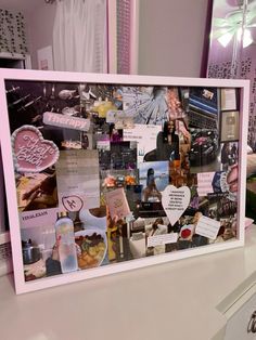 a collage of photos and magnets is displayed on a counter top in front of a mirror