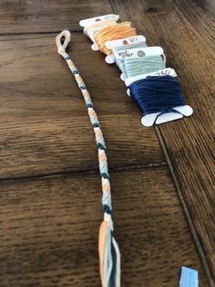 several spools of thread sitting on top of a wooden table