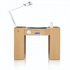 a wooden desk with a laptop on it and a lamp in the corner next to it