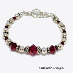 a red and white beaded bracelet with silver beads, pearls and swaronite