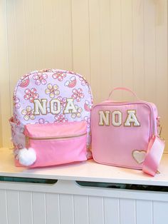 Welcome to Noa Jayne Co where we specialize in personalized backpacks for kids and toddlers! All backpacks are fully customizable and come with sewn on patches to ensure long lasting durability. Our backpacks are perfect for daycare, school, traveling, and make for the cutest diaper bag. The perfect personalized gift for kids! We've even recently designed our OWN backpacks from top to bottom! You're looking at one now! **2-piece set includes Daisy backpack and light pink lunch box** Backpack *Fits children who are over 45" tall *Overall: 13" wide x 6" deep x 16" tall  *All gold hardware and zippers *Nylon waterproof fabric *Cup holders on both sides *Interior zipper pocket *Two pom pom keychains included (white and pink) *Leather bottom *Noa Jayne Co EXCLUSIVE backpack design - you won't f Customizable Cute Backpack For School Events, Cute Customizable Backpack For Gift, Customizable Cute Bags For School Events, Cute Pink Backpack For School Events, Cute Rectangular Backpack For School Events, Pink Backpack For End Of School Year Gift, Pink Backpack Gift For End Of School Year, Cute Customizable Standard Backpack, Cute Standard Backpack Customizable