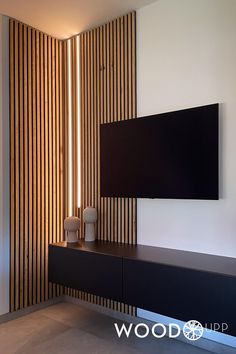 a flat screen tv mounted to the side of a wall next to a wooden cabinet