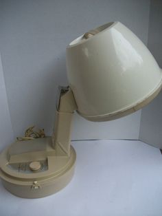 an old style lamp with a cord attached to it's base on a white surface