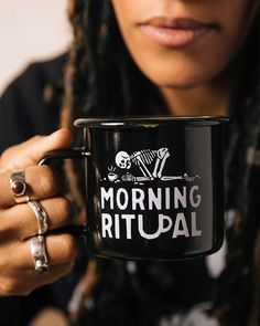 a woman holding a black coffee mug with the words morning ritual on it