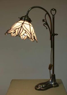 a lamp that is sitting on top of a table next to a light fixture with a flower design