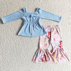 two children's clothing laying on the floor next to each other and one is blue