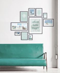 a green couch sitting in front of a white wall with pictures on the wall above it