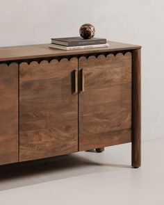 a wooden cabinet with two doors and a book on top