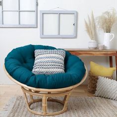 a chair with a pillow on it in front of a table and two framed pictures