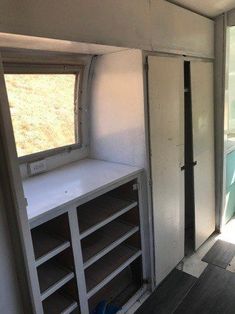 the inside of an rv with shelves and windows