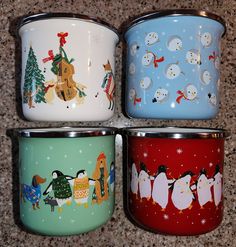 four different colored mugs with penguins and snowmen painted on the sides, all lined up in a row