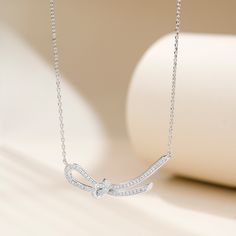 This necklace features a knot designed in the form of a ribbon, crafted with sterling silver. The delicate and elegant design of the pendant showcases the artistry and craftsmanship involved in its creation. The silky smooth texture of the ribbon adds a touch of sophistication to any outfit, making it a versatile accessory for both casual and formal occasions. This pendant necklace is a perfect choice for those who appreciate timeless elegance and desire to make a fashion statement.Carat Weight: Elegant Adjustable Sterling Silver Necklace, Elegant Adjustable Necklace As Gift For Her, Elegant Butterfly Knot Jewelry Gift, Formal Sterling Silver Jewelry With Ribbon, Elegant Ribbon Jewelry For Anniversary, Elegant Butterfly Knot Jewelry For Gift, Elegant Bow Necklace For Anniversary, Elegant Infinity Necklace For Gifts, Formal Butterfly Knot Necklace