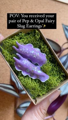 someone is holding a small box with some fake animals in it and the words pov you received your pair of pop & opal fairy slug earrings