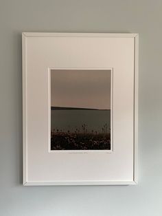 an empty white frame hanging on the wall