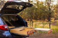 the back end of a car with its trunk open and two wooden boxes in it