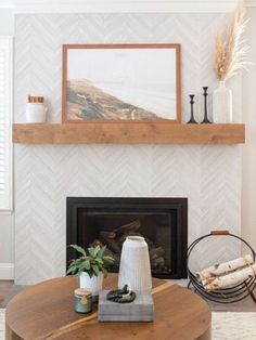 a living room with a fire place and a painting on the wall above it's mantle