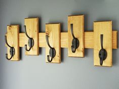 five wooden hooks are attached to the wall