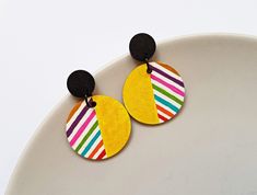 "Add a pop of vibrant color to your accessories collection with these stunning hand-painted rainbow striped round wood earrings. Each earring is crafted with meticulous attention to detail, creating a unique and eye-catching piece. The rainbow stripes radiate a joyful energy and will surely brighten up any outfit. These earrings are designed with stainless steel posts, ensuring durability and comfort for all-day wear. Whether you're heading to a fun-filled festival or simply want to add a playfu Cheap Hand Painted Round Earrings, Affordable Hand Painted Round Earrings, Hand Painted Earrings Wood, Polyclay Ideas, Artsy Fashion, Creative Earrings, Painted Rainbow, Rave Accessories, Accessory Ideas