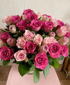 a vase filled with pink roses on top of a table