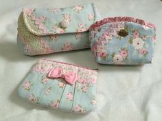 four small purses with bows on them sitting on a bed next to each other