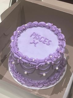 a purple frosted cake sitting in a box