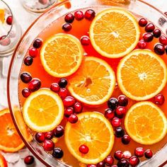 sliced oranges and cranberries in a glass bowl