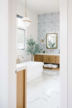 a bathroom with marble flooring and walls, along with a large mirror on the wall