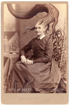 an old photo of a woman sitting on a chair with hair blowing in the wind