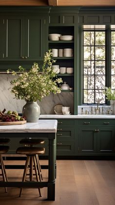 a kitchen with green cabinets and marble counter tops