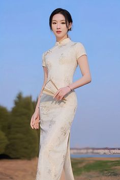 A beautiful woman in a long white qipao Chinese dress with short sleeves Elegant Beige High Neck Dress, Elegant High Neck Beige Dress, Elegant Formal Ao Dai Maxi Length, Elegant White Cheongsam For Spring, Elegant Formal Maxi Length Ao Dai, Elegant Maxi Length Ao Dai For Formal Occasions, Elegant Spring Cheongsam With Stand Collar, Spring Elegant Cheongsam With Stand Collar, White Fitted Cheongsam With Stand Collar