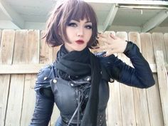 a woman in leather clothes poses for the camera