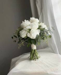 a bouquet of white flowers sitting on top of a table