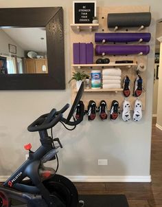 an exercise bike in front of a wall with yoga mats and other items on it