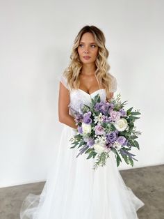 a woman in a wedding dress holding a bouquet