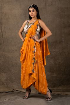 Mango pre-draped dhoti saree with bandhani print and embroidery on the drape. Comes with white embroidered blouse.
Component: 2
Pattern: Embroidery and Print
Type Of Work: Zardozi, Coin, Sequin and Bandhani
Neckline: V neck
Sleeve Type: Sleeveless
Fabric: Crepe
Color: Orange,White
Other Details: 
Scalloped detail at the neckline
Semi elasticated waistband
Occasion: Wedding - Aza Fashions Dhoti Saree, Bandhani Print, White Embroidered Blouse, White Saree, Drape Saree, Luxury Sale, Pattern Embroidery, Blouse For Women, Saree With Blouse