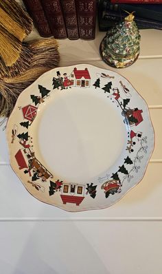 a white plate with christmas decorations on it next to books and a small potted plant