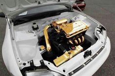 the engine compartment of a white car with gold trim