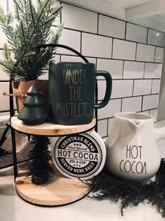 two mugs and a potted plant on a shelf