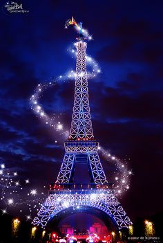 the eiffel tower is lit up at night with fireworks in the sky above it