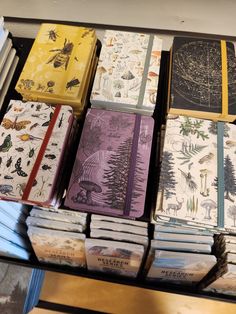 many books are stacked on top of each other in a book store display case that is filled with different types of books