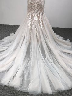 the back of a wedding dress with sheer tulle and appliques on it