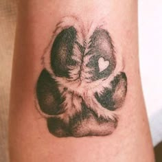 a tattoo on the arm of a person with a dog paw and heart in it