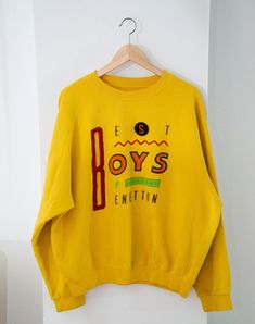 Made in Italy, 90s United Colors of Benetton 'Boys of Benetton' cotton sweatshirt. The sweatshirt is in flawless condition. Comes with a removable velcro 'S' which is a cool and unique feature! Size XL Length 23 cm Width 24 cm Shoulder to Shoulder 22cm 90s Style Cotton Sweater, 90s Style Multicolor Long Sleeve Sweatshirt, 90s Cotton Sweatshirt For Streetwear, 90s Cotton Sweatshirt With Graphic Print, 90s Cotton Sweater With Graphic Print, Retro Yellow Sweatshirt For Streetwear, Affordable Yellow 90s Style T-shirt, Retro Yellow Cotton Sweatshirt, 90s Graphic Print Cotton Sweater