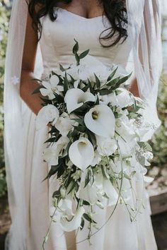 a bride holding a bouquet of white flowers